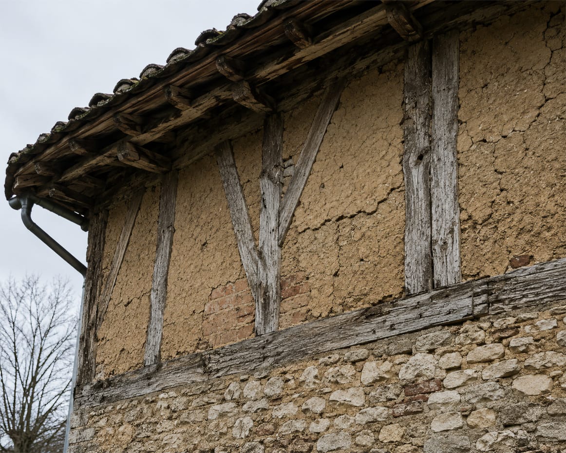 Détail d'une façade bressane associant pan de bois, remplissage torchis et soubassement maçonné